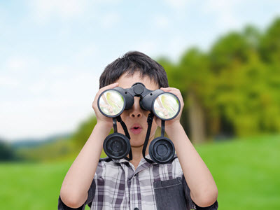 boy at summer camp in Frederick looking through binoculars